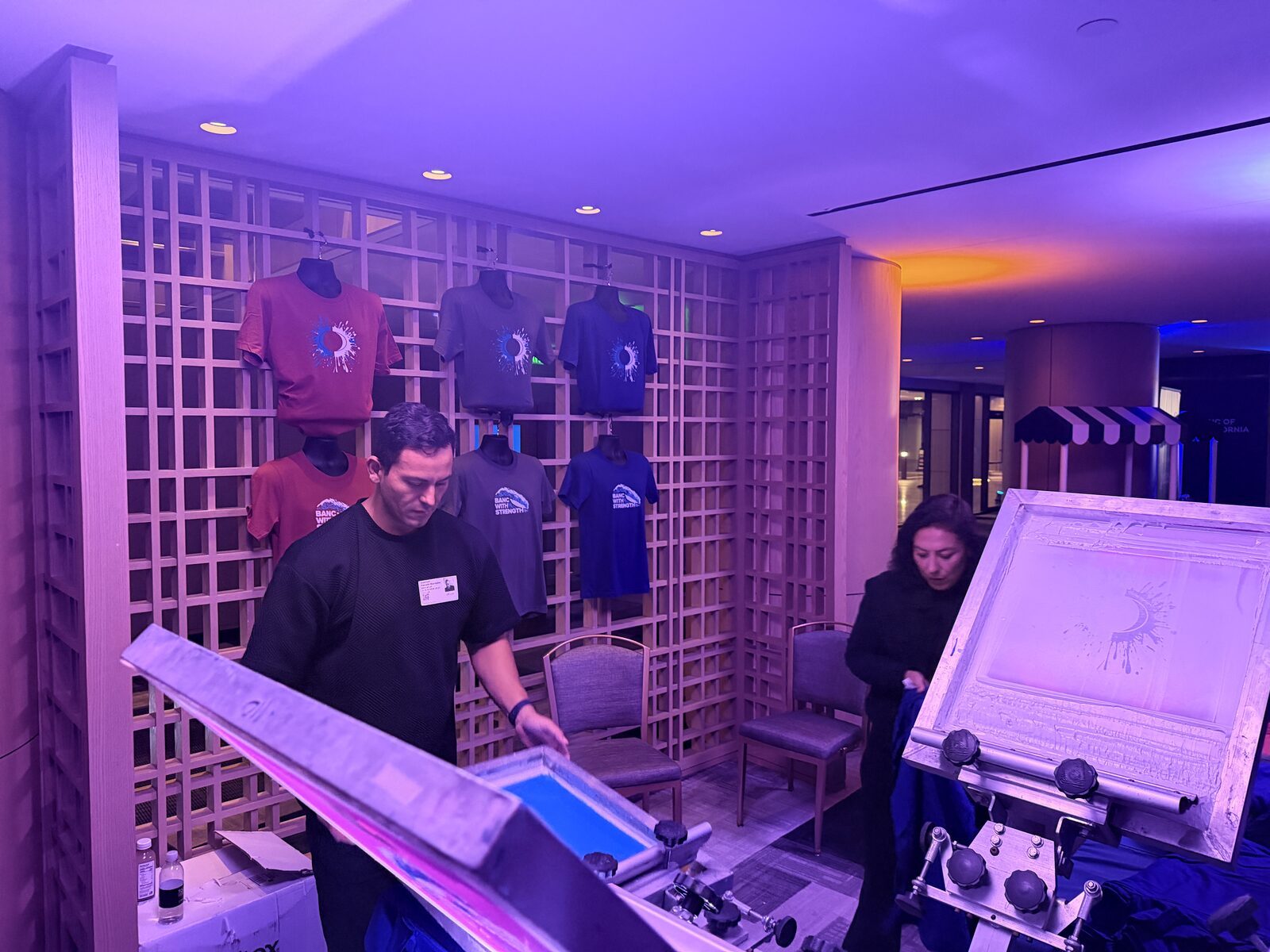Finished event shirts displayed on a wall so attendees can browse the day's designs